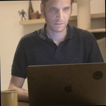 a man sitting at a table with a laptop