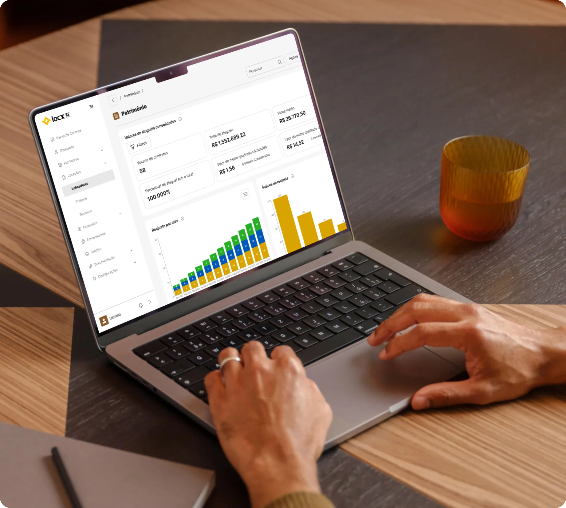 Pessoa usando um laptop mostrando uma tela com painel de controle financeiro e gráfico de valores de aluguéis.