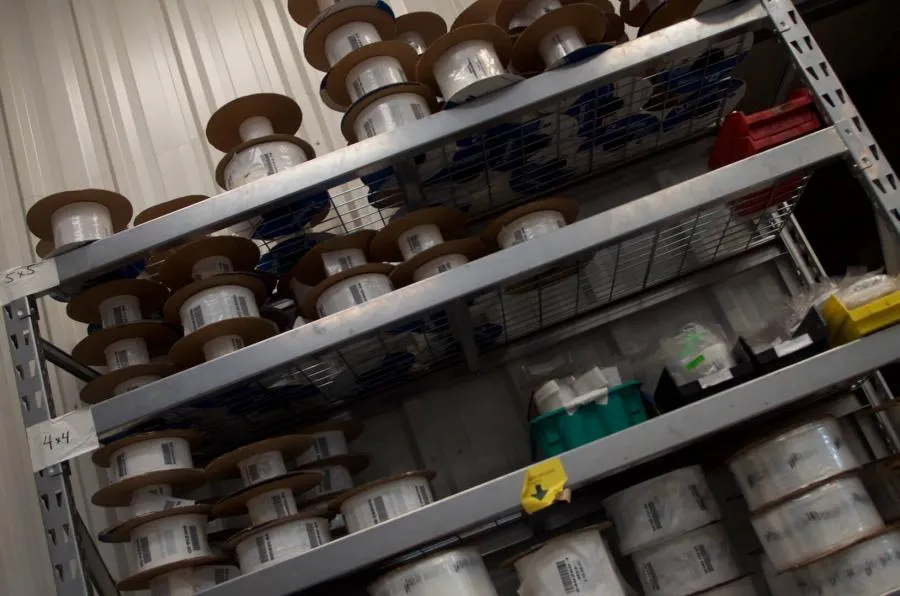 Rolls of printed packaging film stored on warehouse shelving
