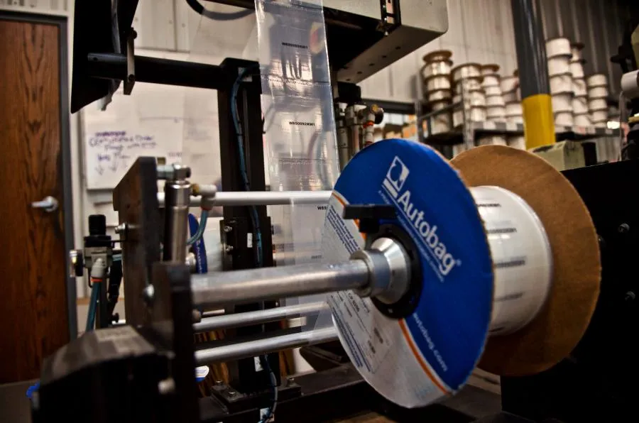 Printed packaging film feeding through an automated bagging machine