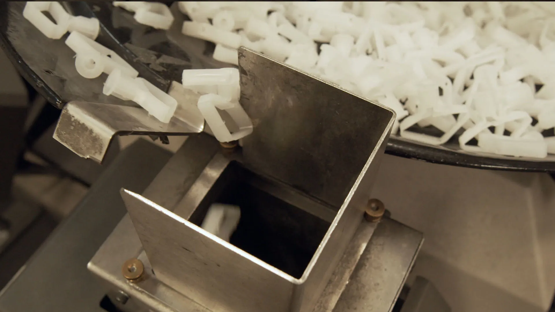 White plastic components inside an automated bowl sorter