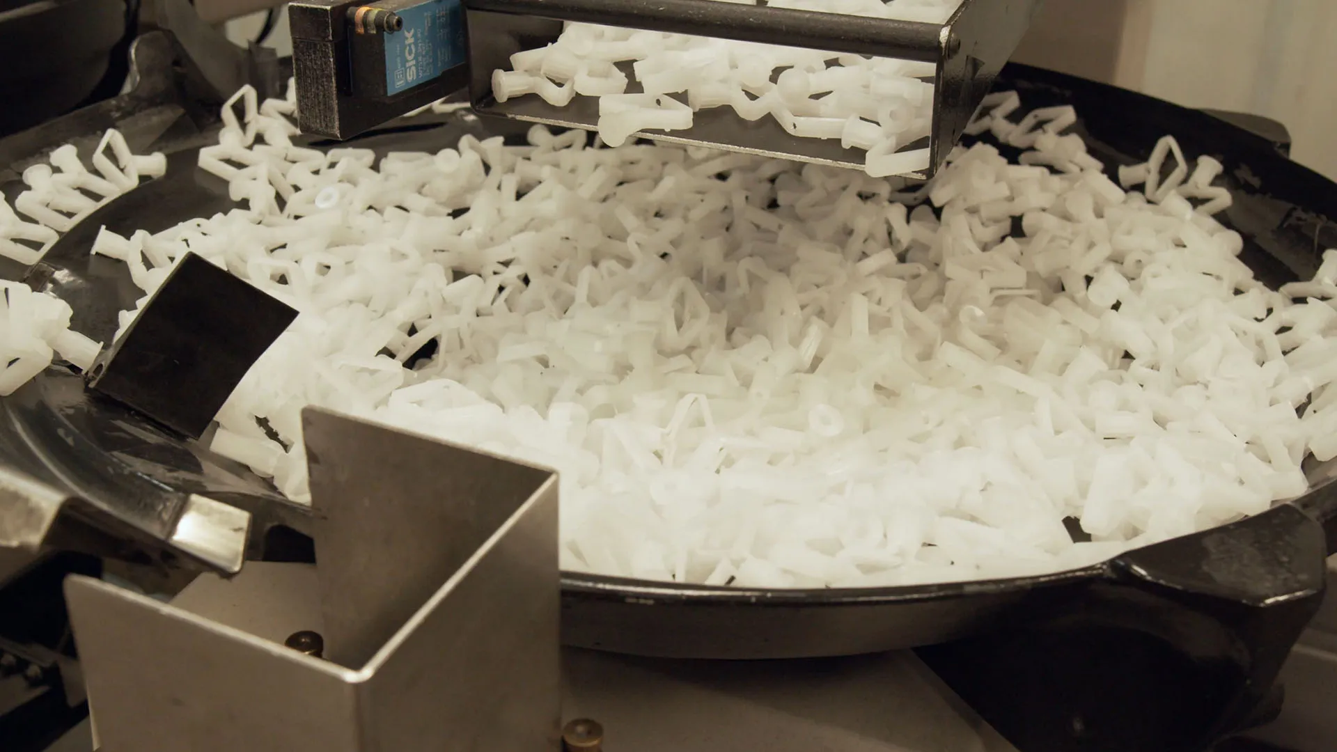 White plastic components inside an automated bowl sorter