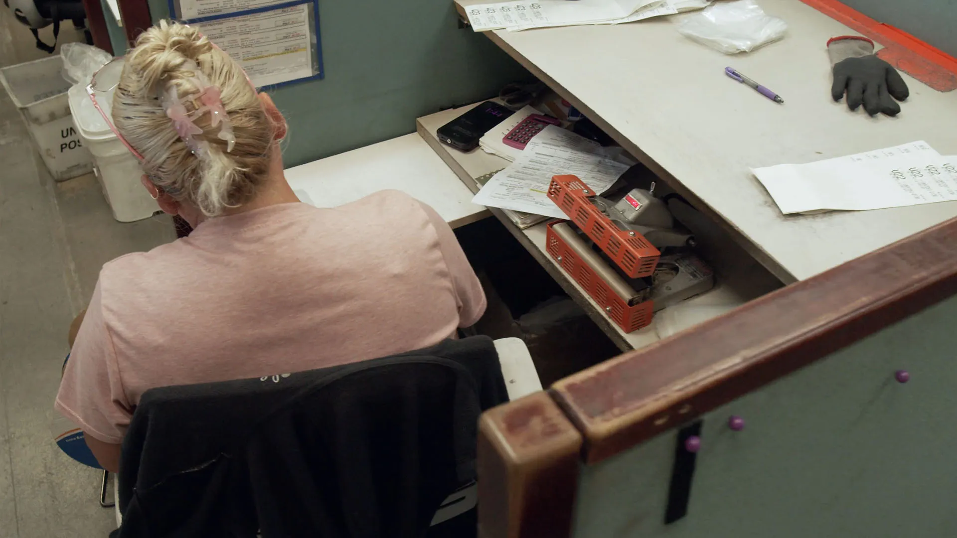 Packaging employee processing paperwork at a workstation