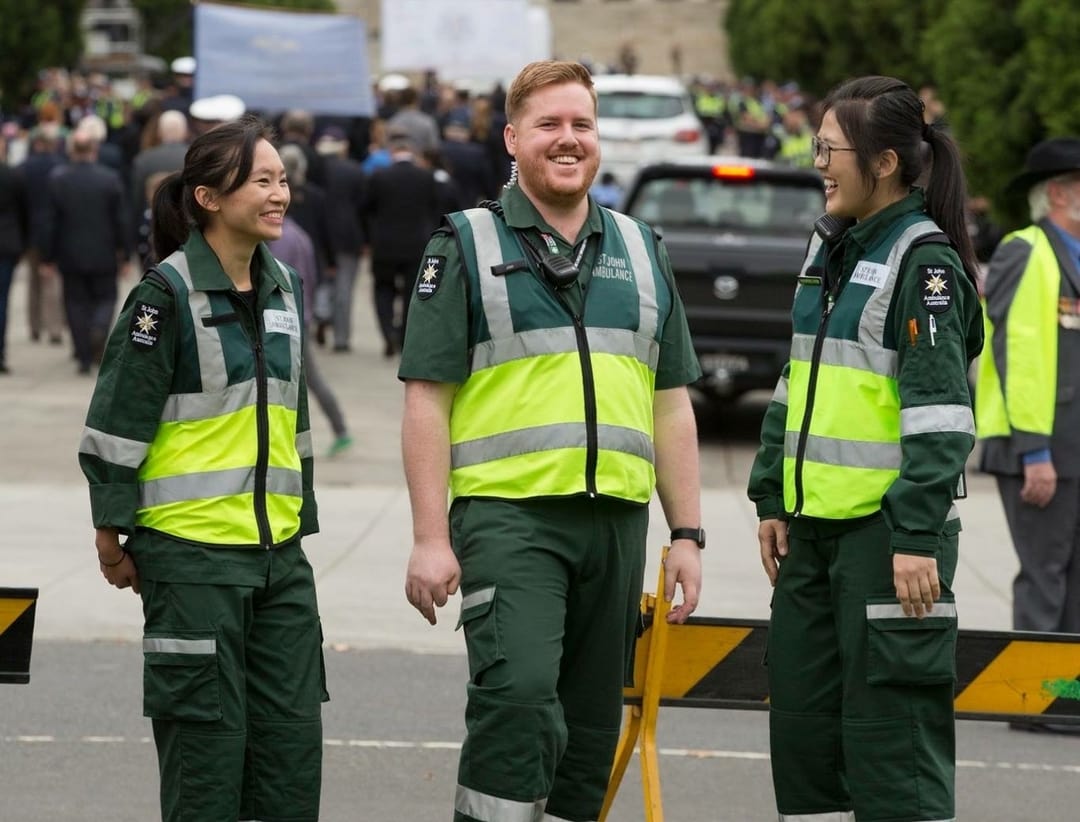 Josh smiling standing in front of a brick wall.