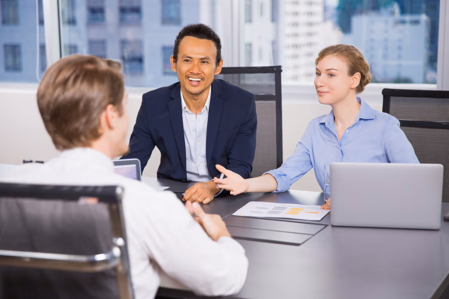 Two employers interviewing a candidate in an office setting