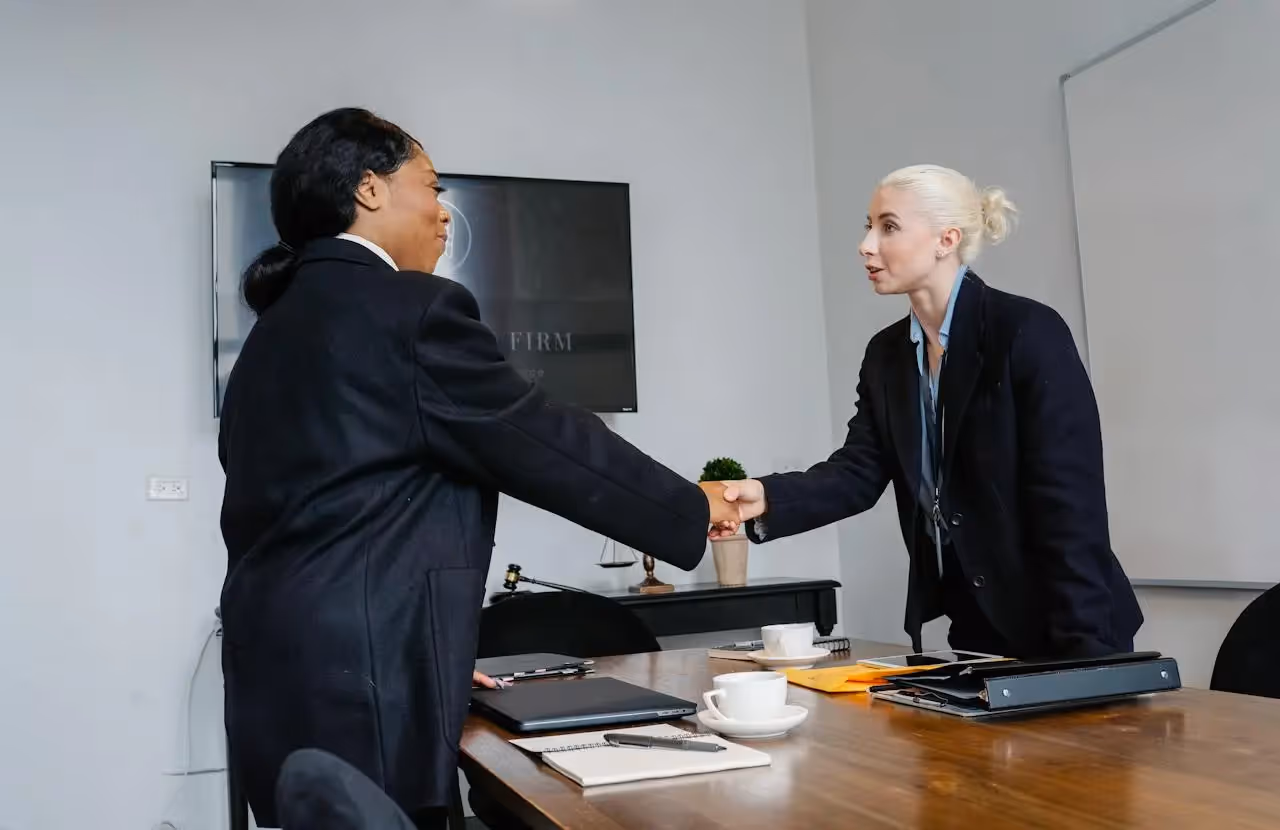 A TA partner and a newly hired candidate shaking hands after their onboarding