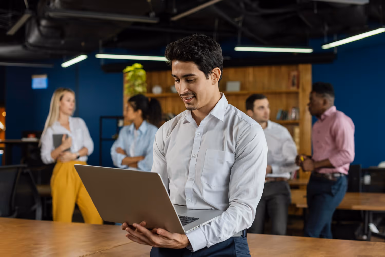 A team of Latinas and Latinos working and talking in the office
