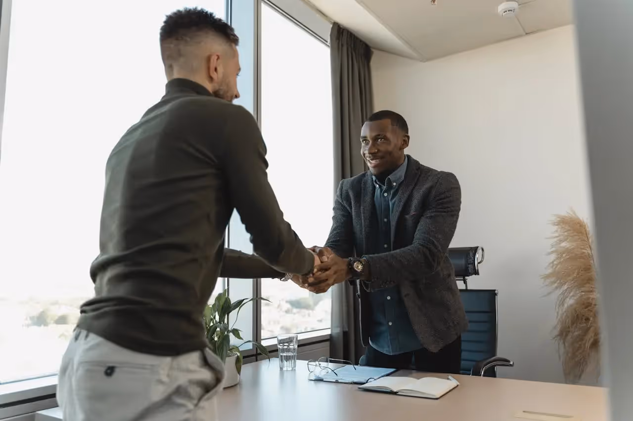 A recruiter shaking hands with a candidate that they just hired