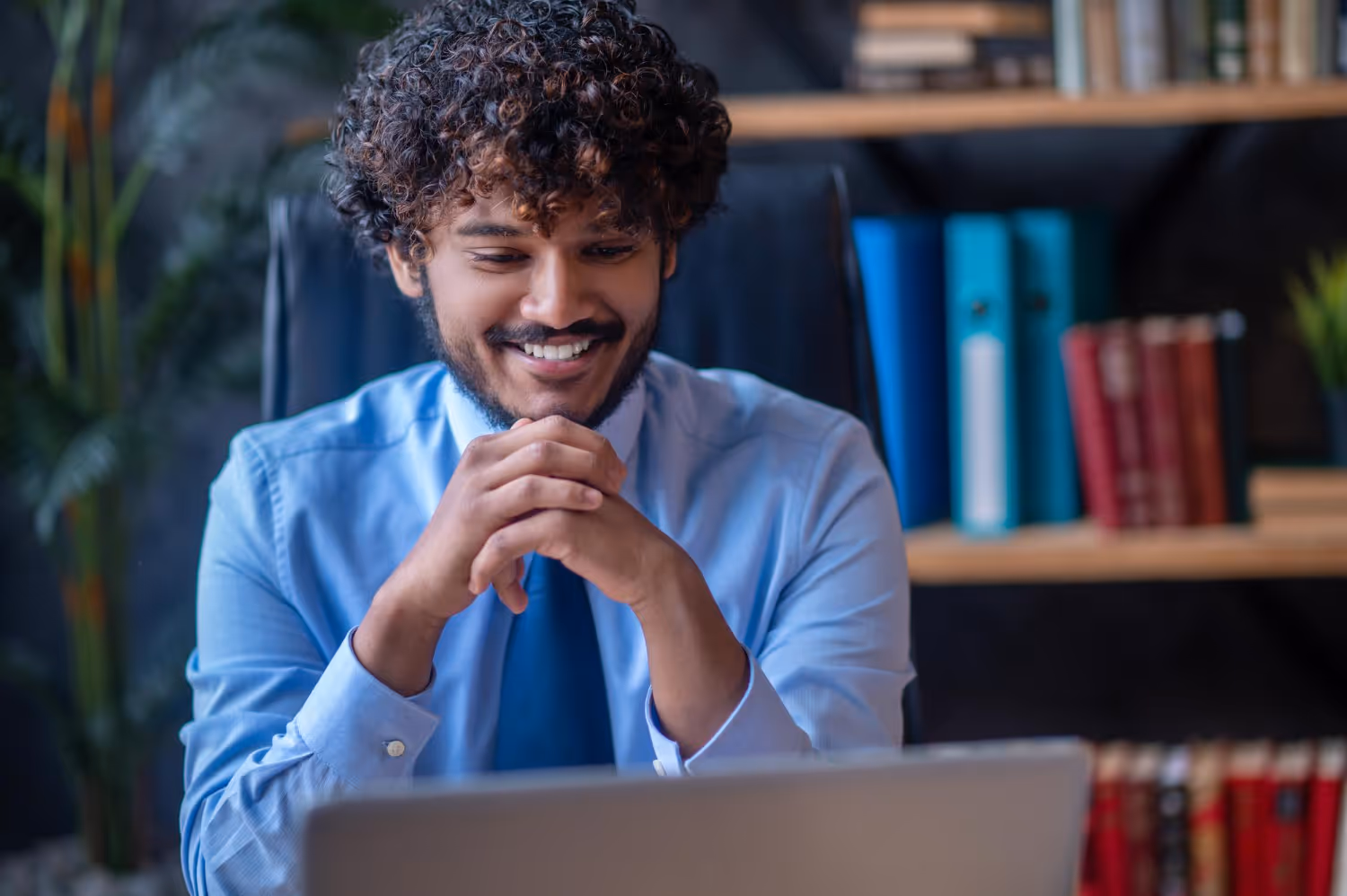 PEO representative smiling at his computer, talking to a business