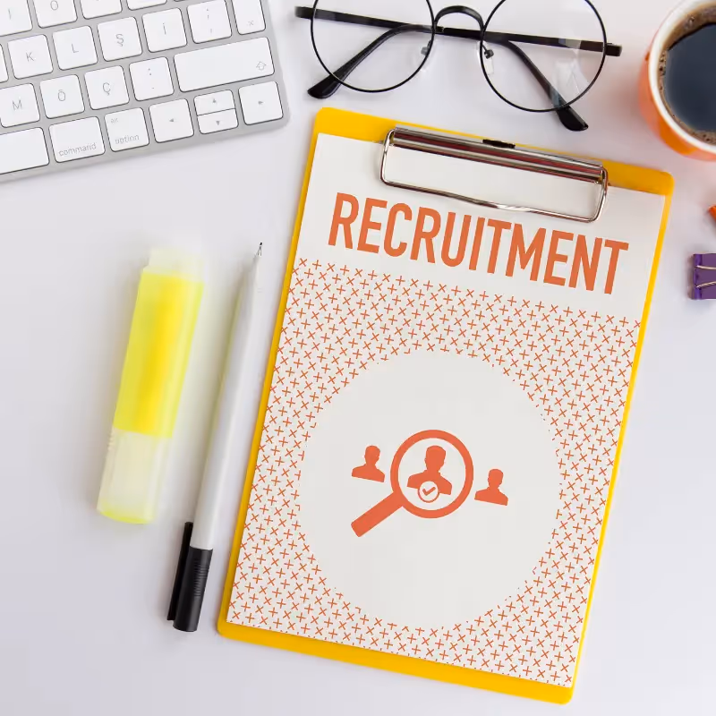 keyboard, eyegalss, highlighter, pens and clipboard showing word recruitment