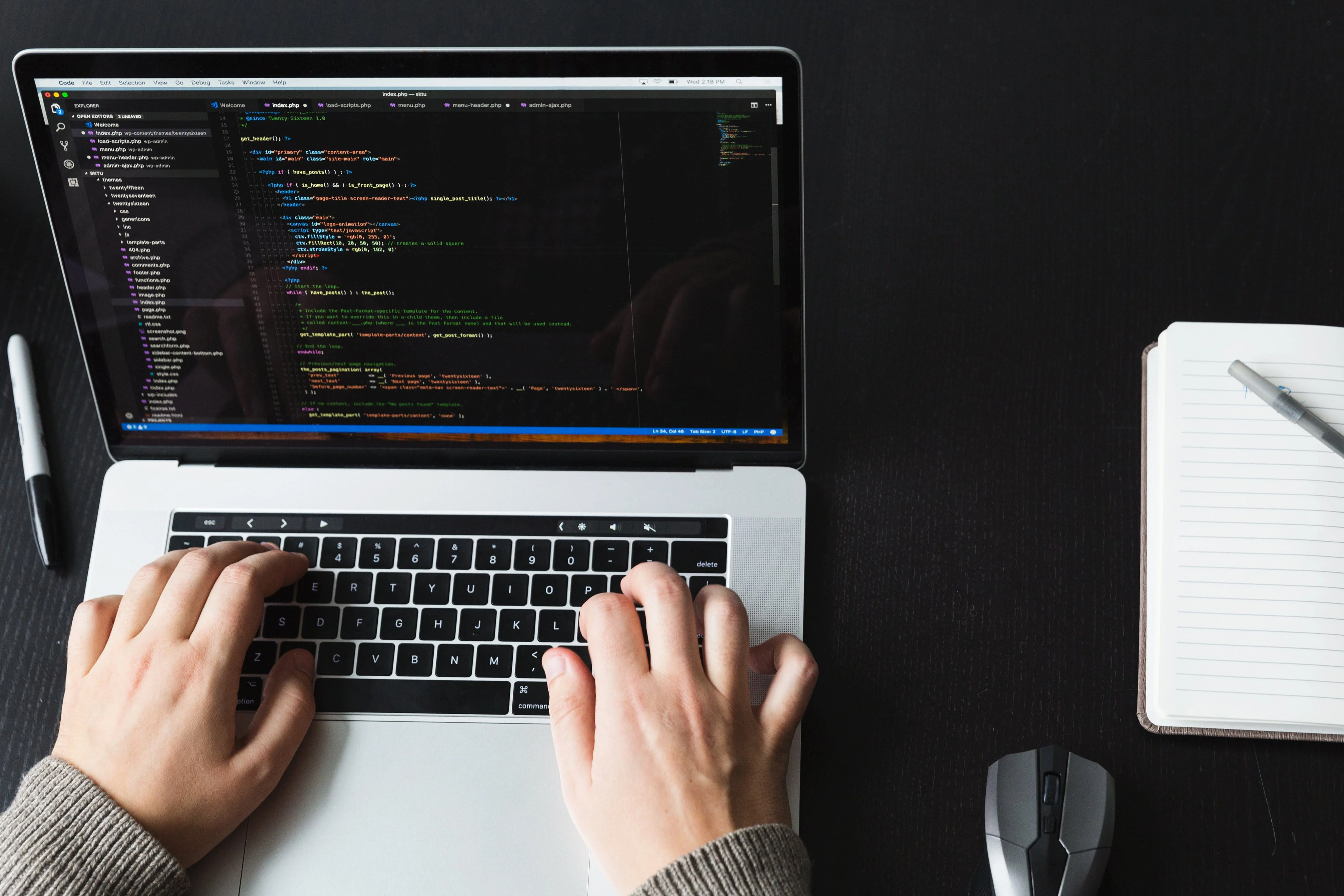 Developer's hand coding on a laptop.
