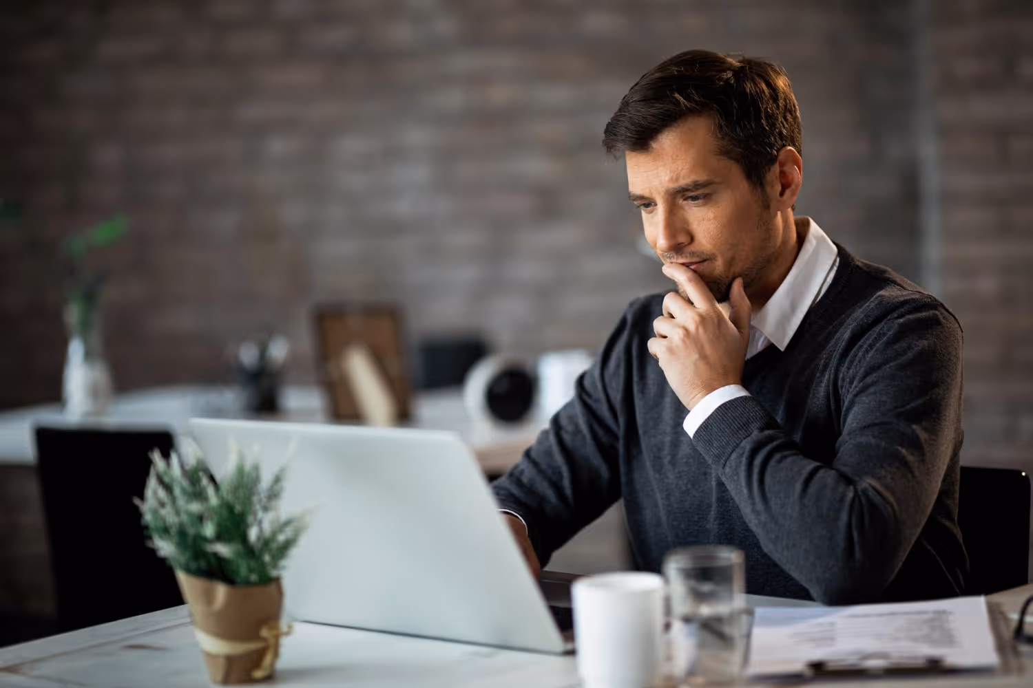 man thinking in front of his computer