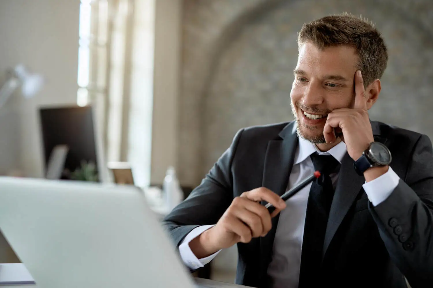 High-Ticket Remote Closer smiling while looking at his laptop
