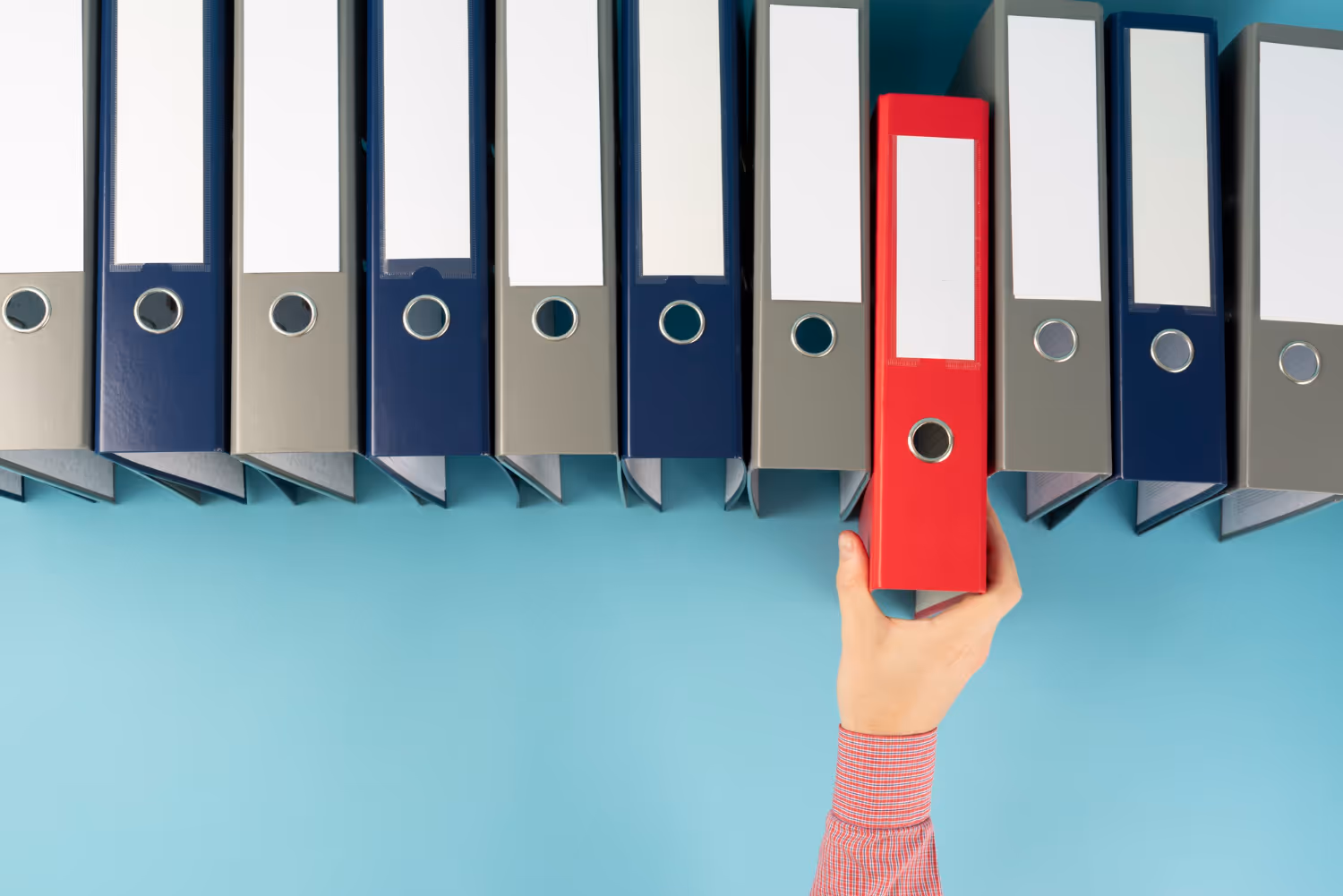 Employer of record reaching for a red binder