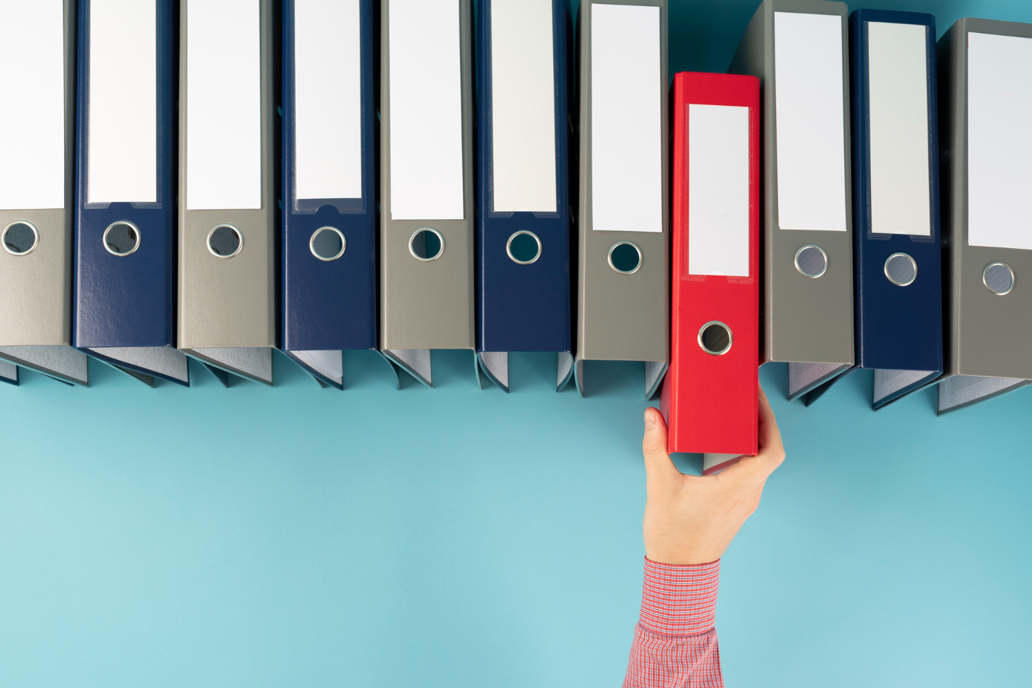 Employer of record reaching for a red binder