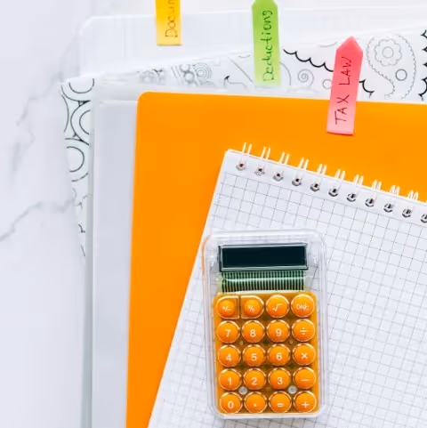 Calculator on top of notebook computing taxes