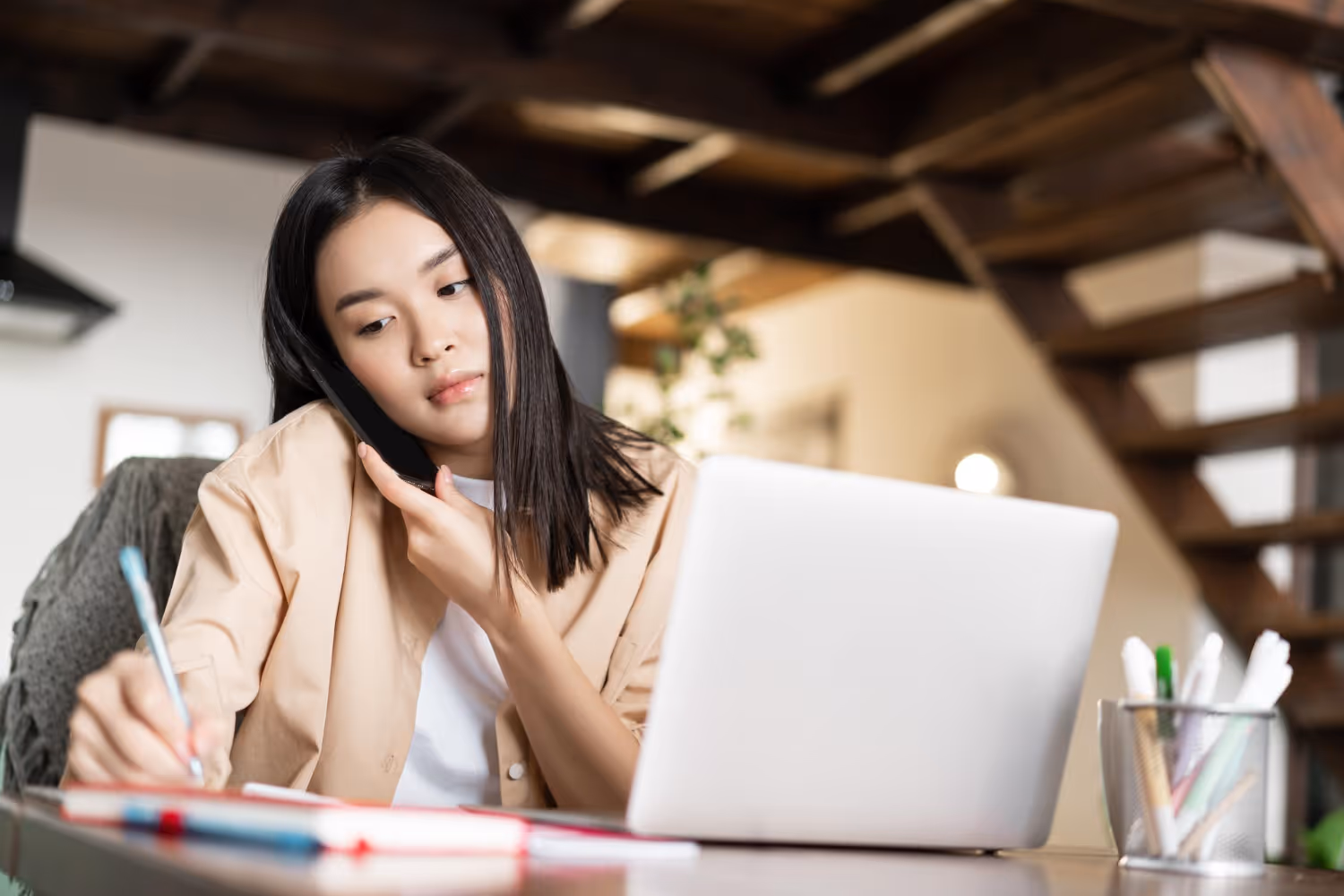 Recruiter writing down on her notes while talking to a remote job candidate