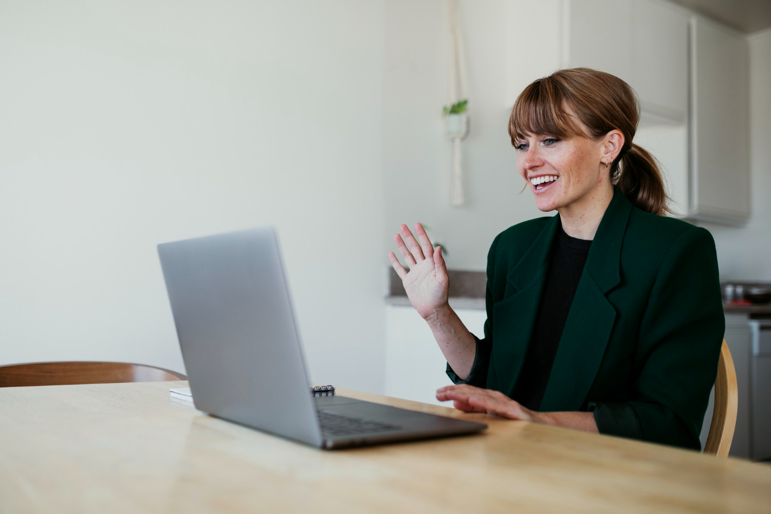 woman smiling and waving at her laptop