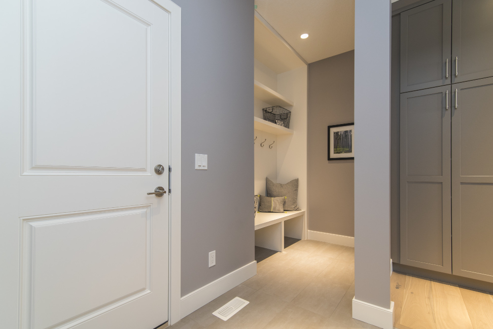 A hallway with a white door and a gray wall.