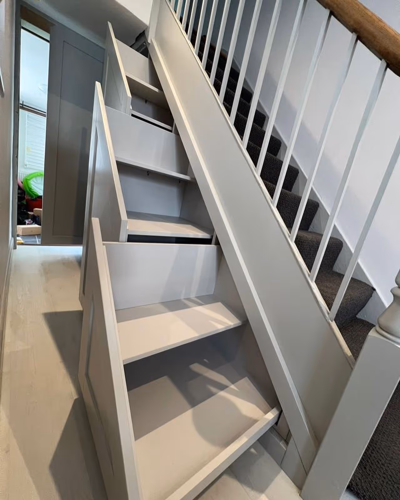 Gray staircase with built-in storage drawers underneath each step, located indoors.