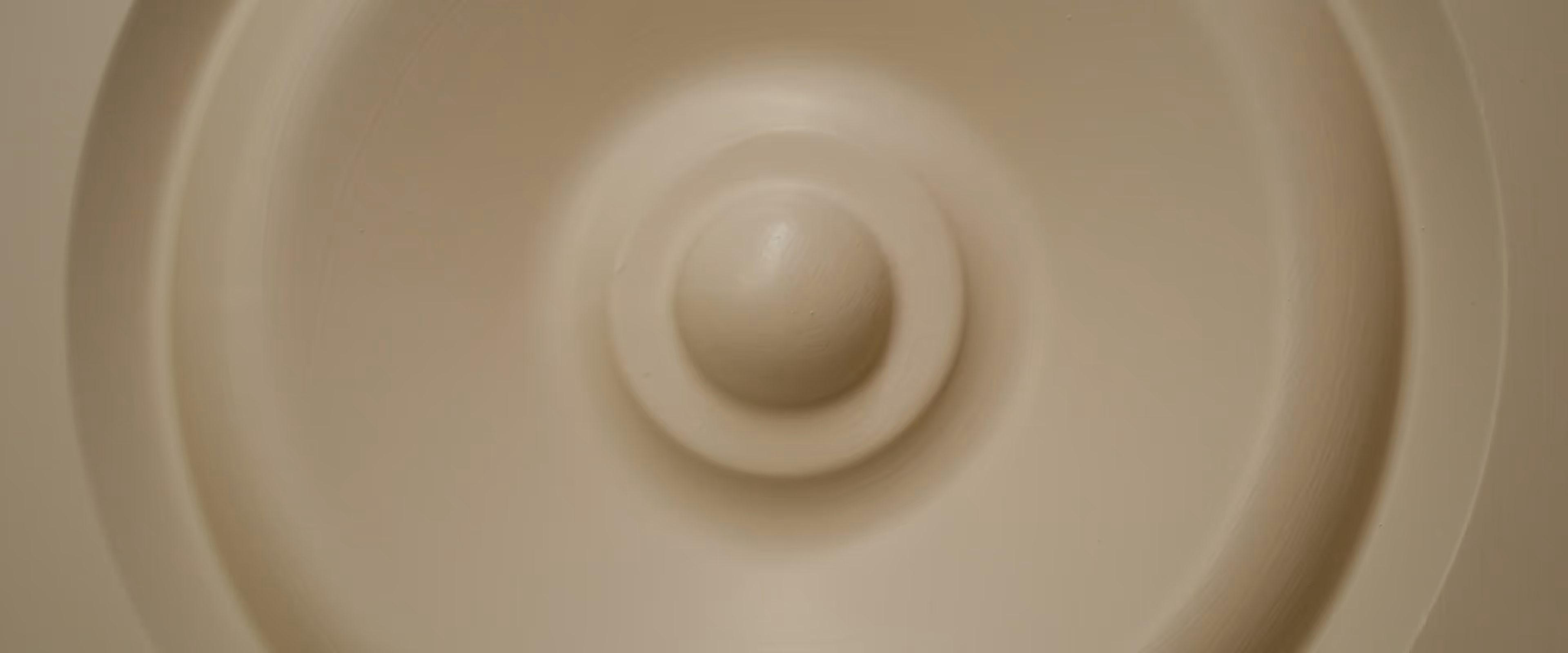 Close-up of a smooth, circular ceiling fixture centered in the image.