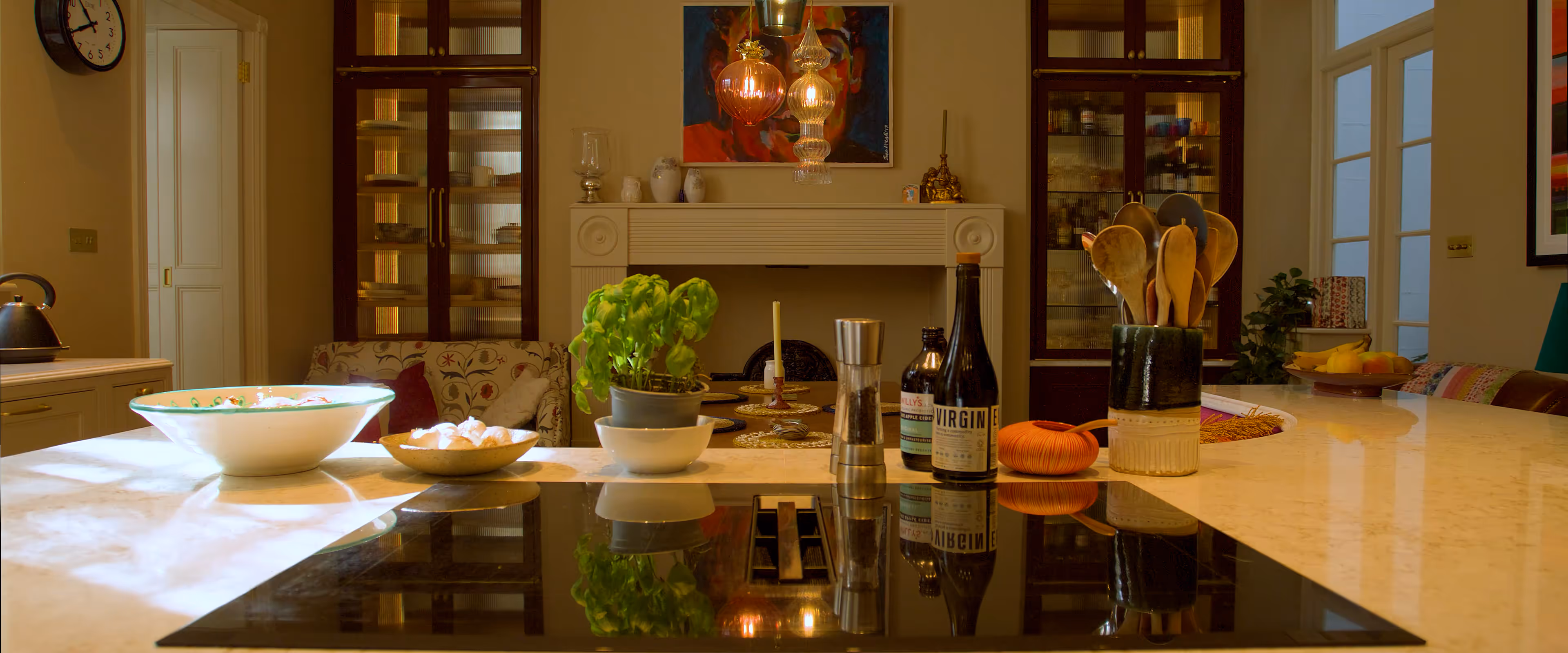 A kitchen with a marble countertop featuring a stove, various spices, and cooking utensils.