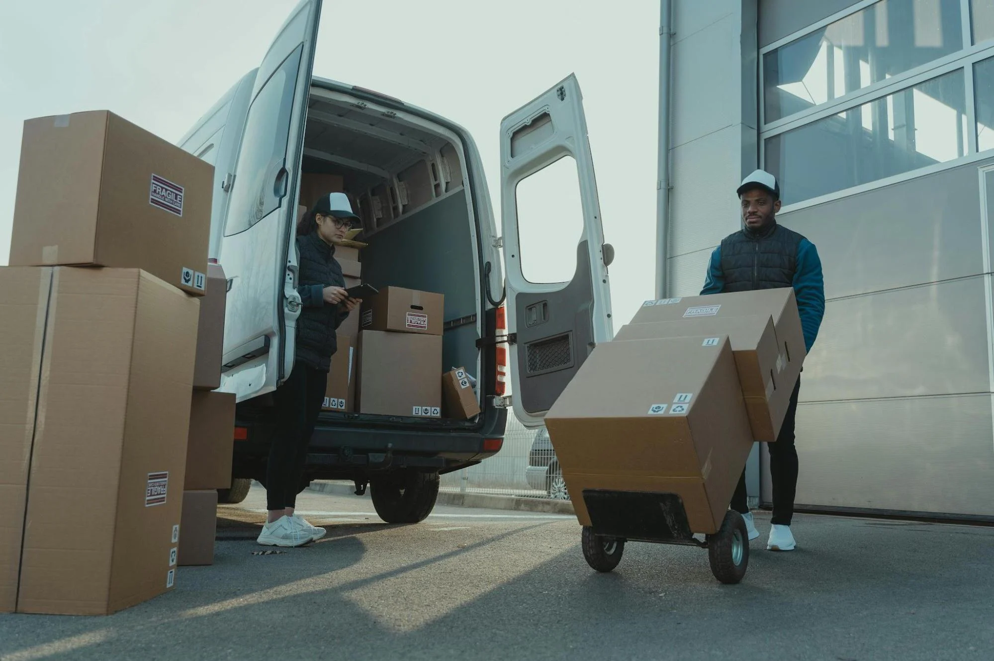 Delivery workers scanning packages, representing logistics businesses benefiting from faster cash flow.
