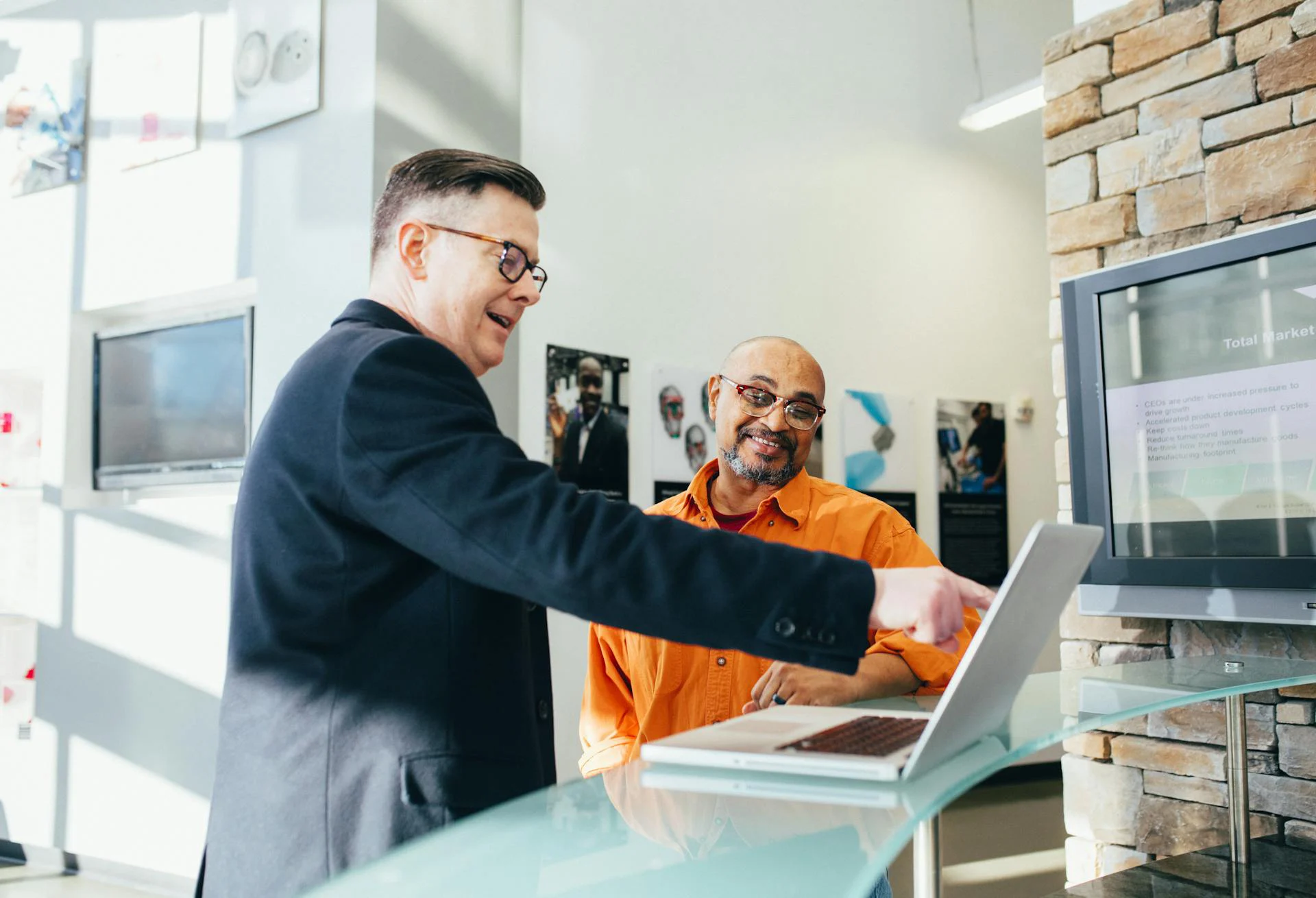 Business professional pointing at a laptop screen while reviewing financial options and comparing lending approaches