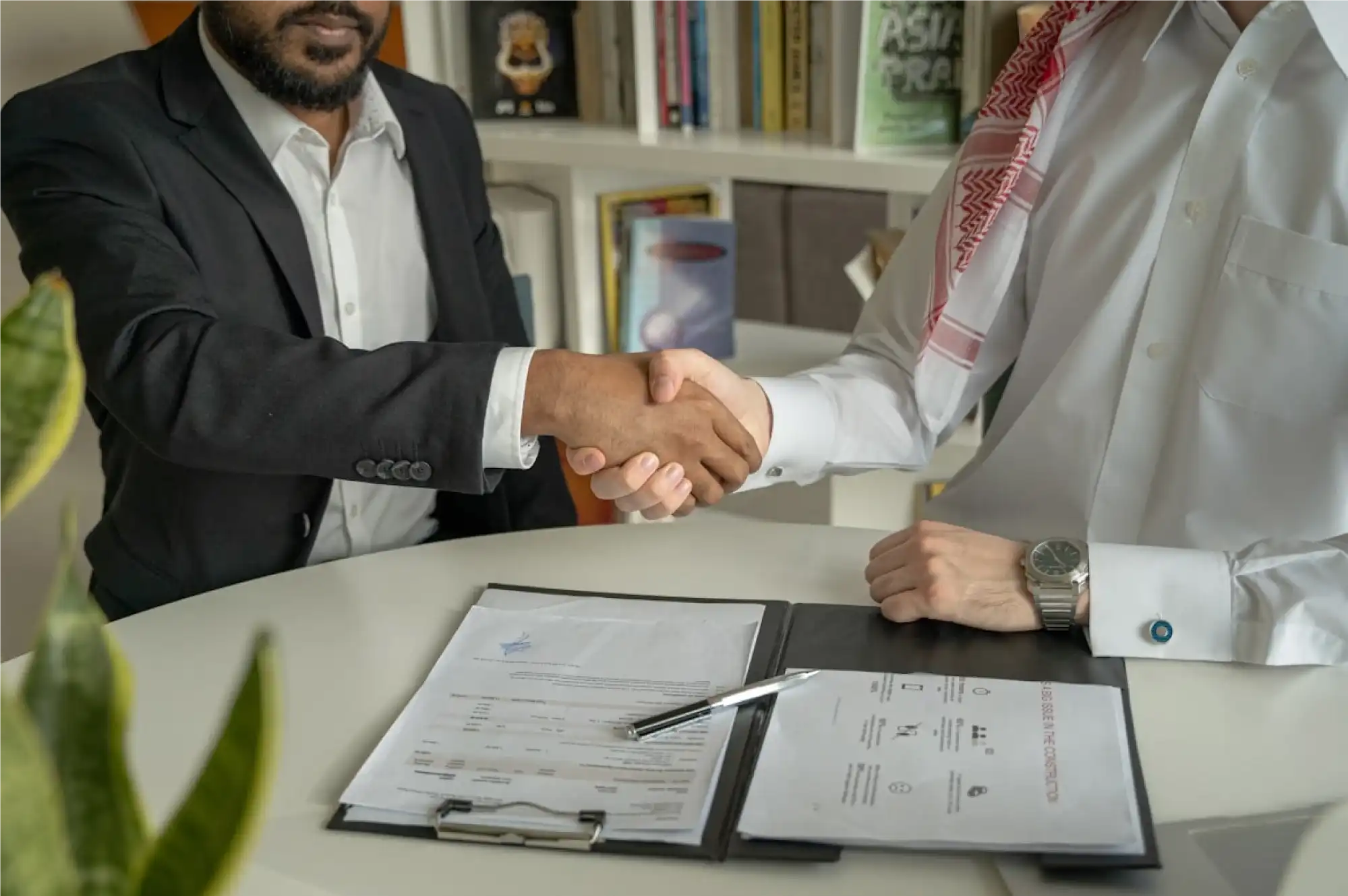 Business partners shaking hands after agreeing on invoice factoring support.