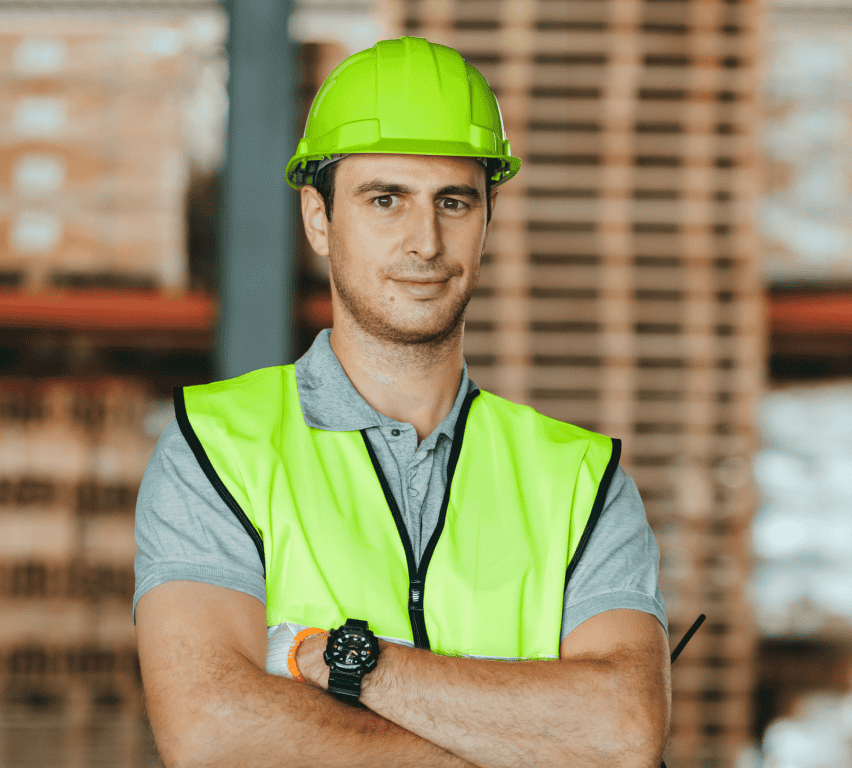 Distribution center worker in hi-vis vest and hard hat in front of stacked pallets, keeping outbound shipments on schedule with Goramp