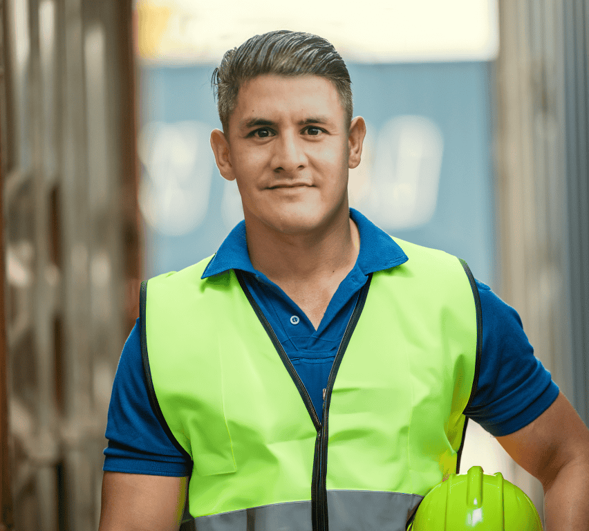 Warehouse yard worker in hi-vis vest holding a hard hat at the loading area, managing gate check-ins with Goramp