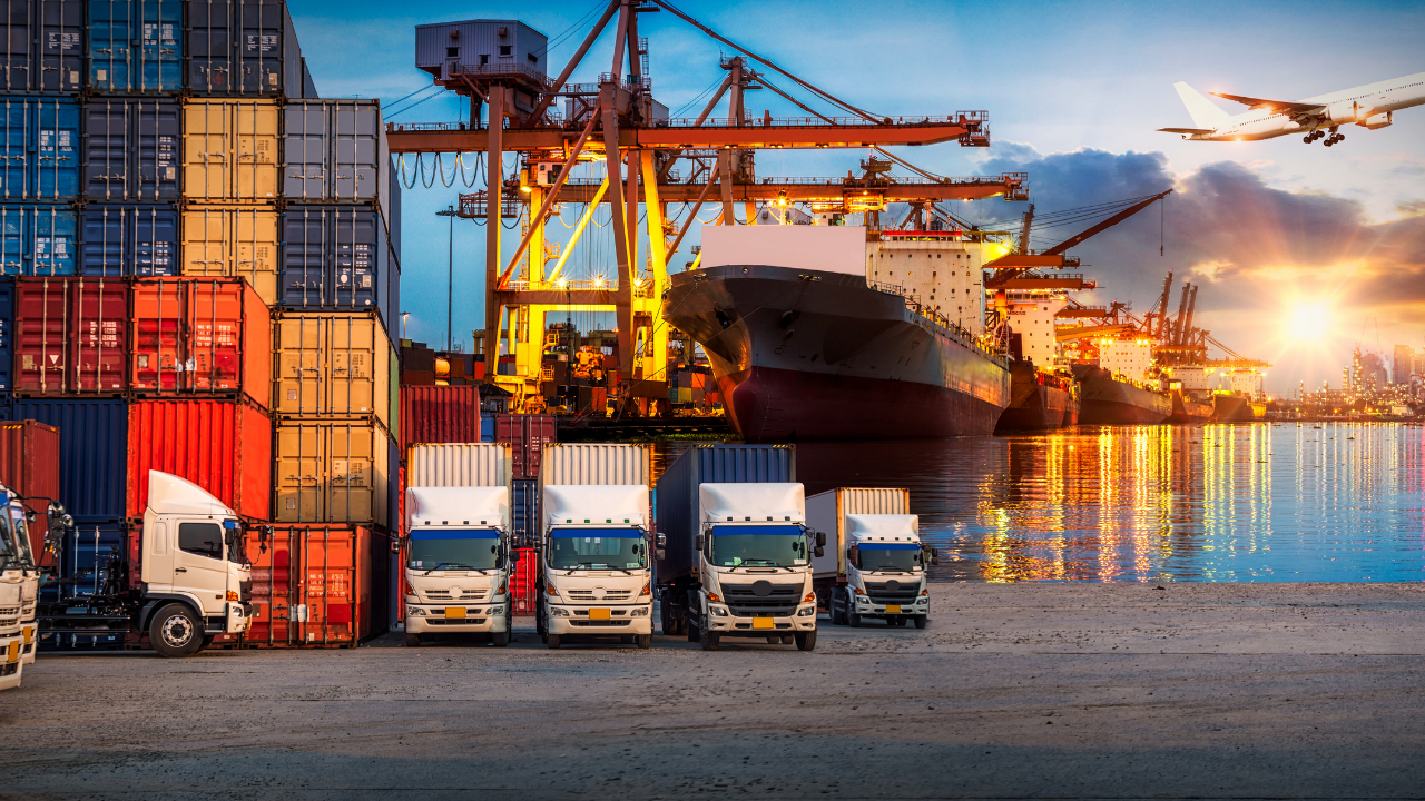 docks and trucks by the water with an aeroplane above