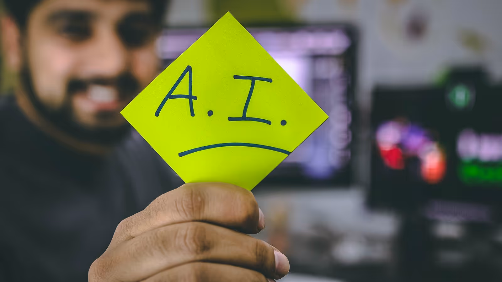 A Man holding A Post-it with A.I. written on it
