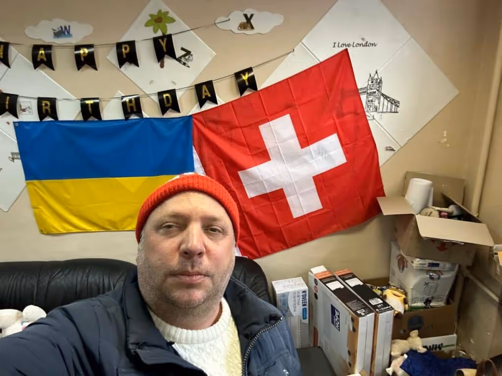 Bänz Margot vor der ukrainischen und schweizer Fahne