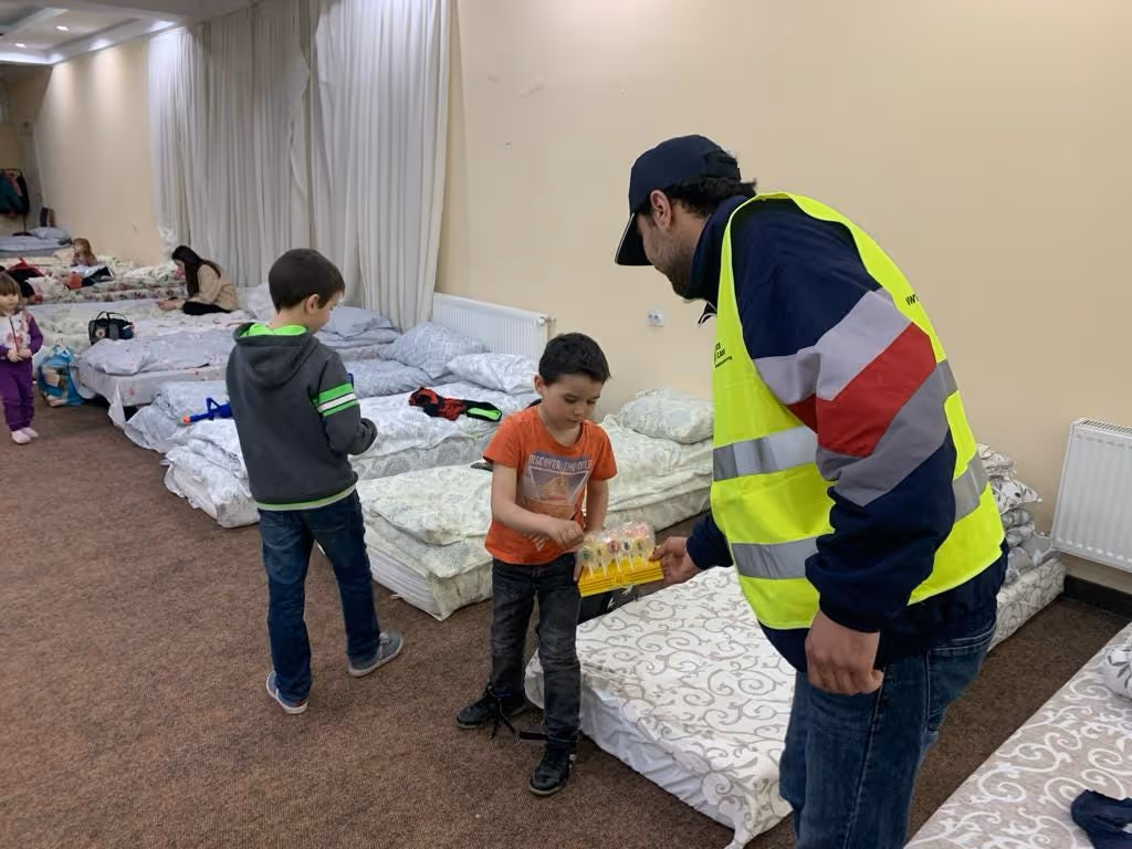 A volunteer from Human front aid gives sweets to children