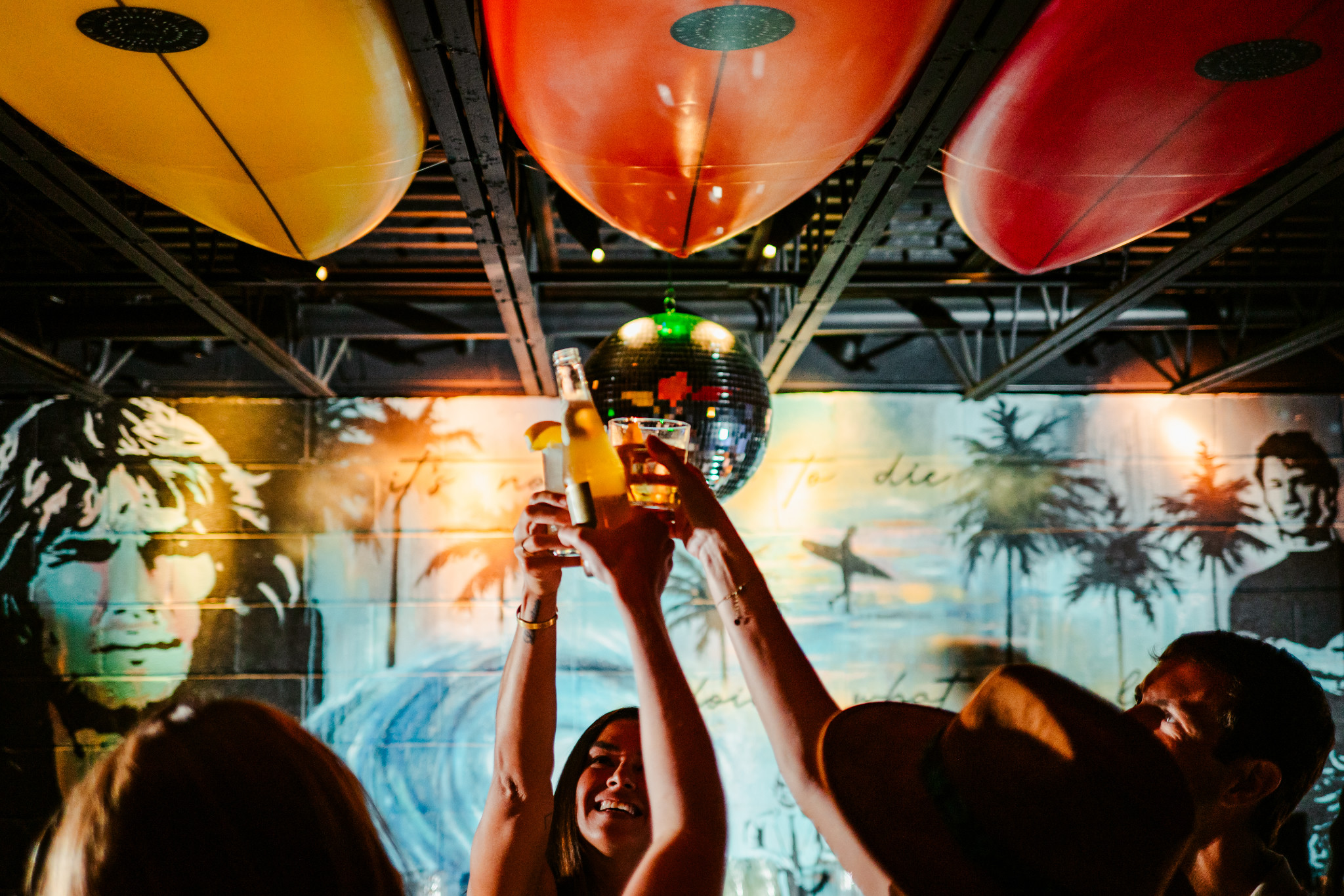 Drinks raised beneath surfboards and a disco ball at Swayze's
