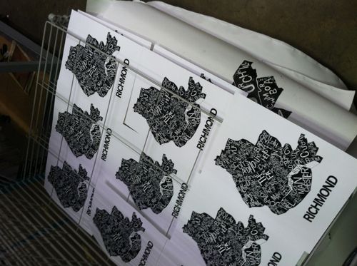 Prints of RVA typographic map screen prints drying on a rack zoomed out.