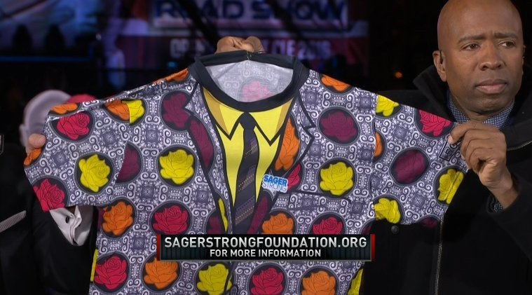 Kenny Smith holding a custom suit for the Craig Sager Strong Foundation on TNT