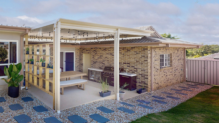 Modern Australian living area opening onto an alfresco entertaining space with large sliding doors and warm evening lighting