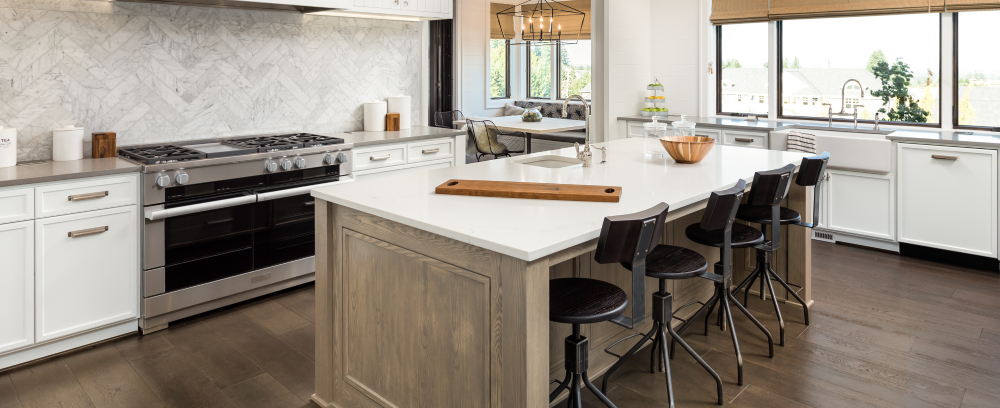 Kitchen interior with island, pendant lights and hardwood floors in a new home