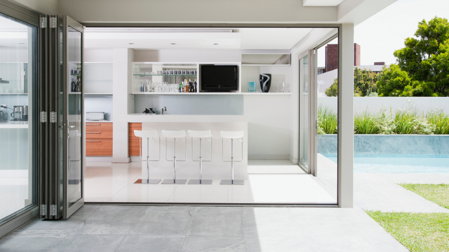 Open-plan living space in a renovated New Zealand home flowing through sliding doors to an outdoor area