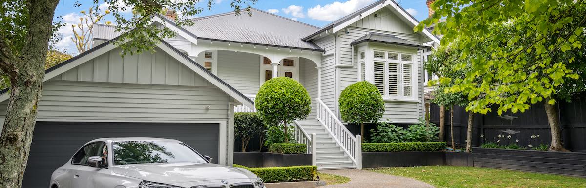 Front of villa exterior with wooden steps and white railing leading to a green front door