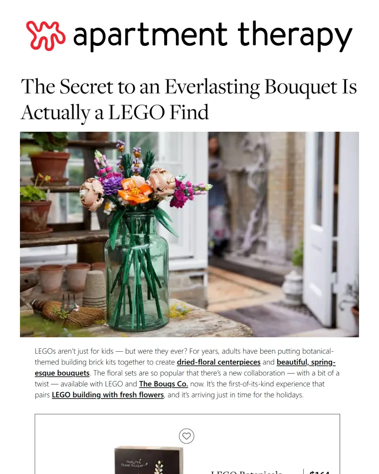 Bouquet of colorful flowers including peach, pink, purple, and orange blooms arranged in a green glass vase on a wooden table indoors.