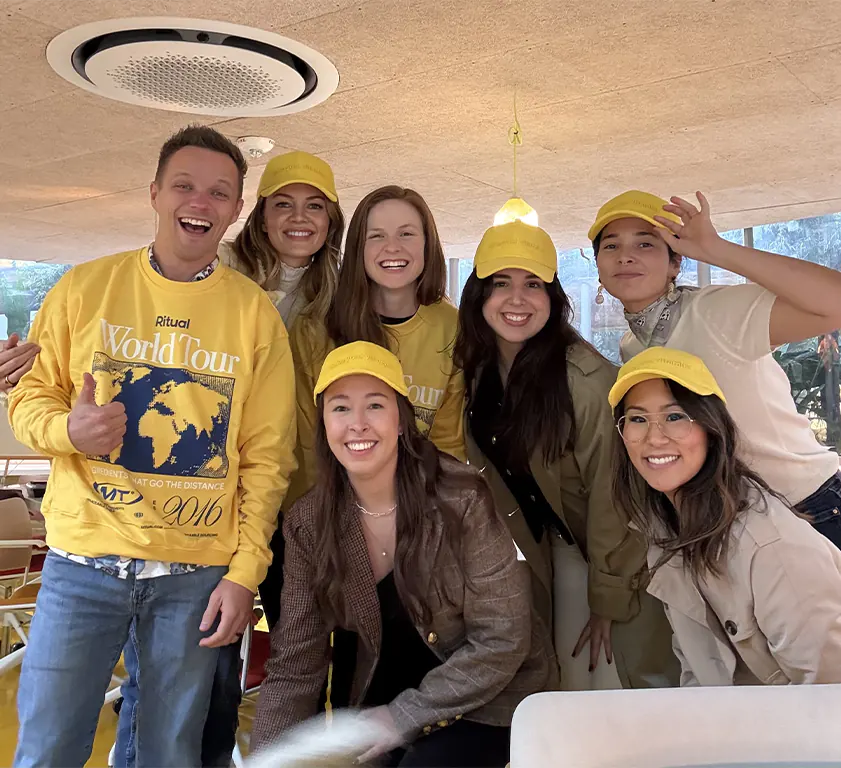 Dreamday team wearing yellow hats and yellow World Tour sweatshirts indoors.