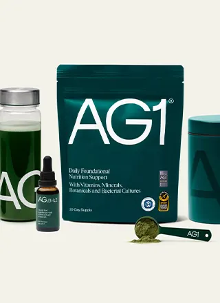 AG1 daily nutritional supplement package with a scoop of green powder and a green drink bottle.