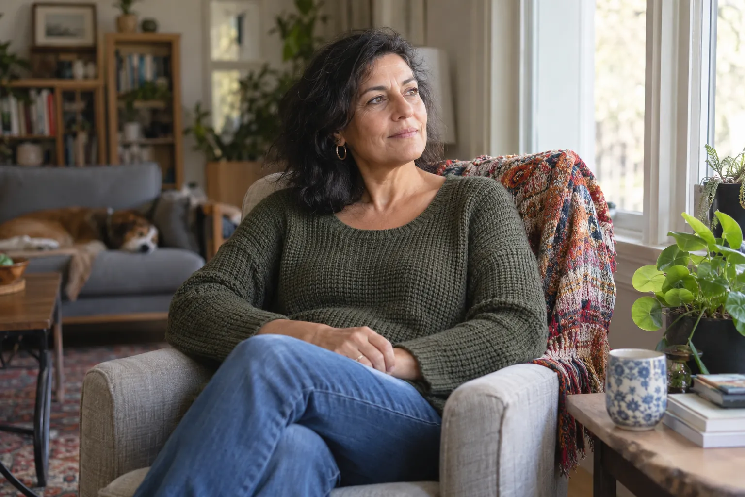 Une adulte prend un temps de pause près d’une fenêtre.