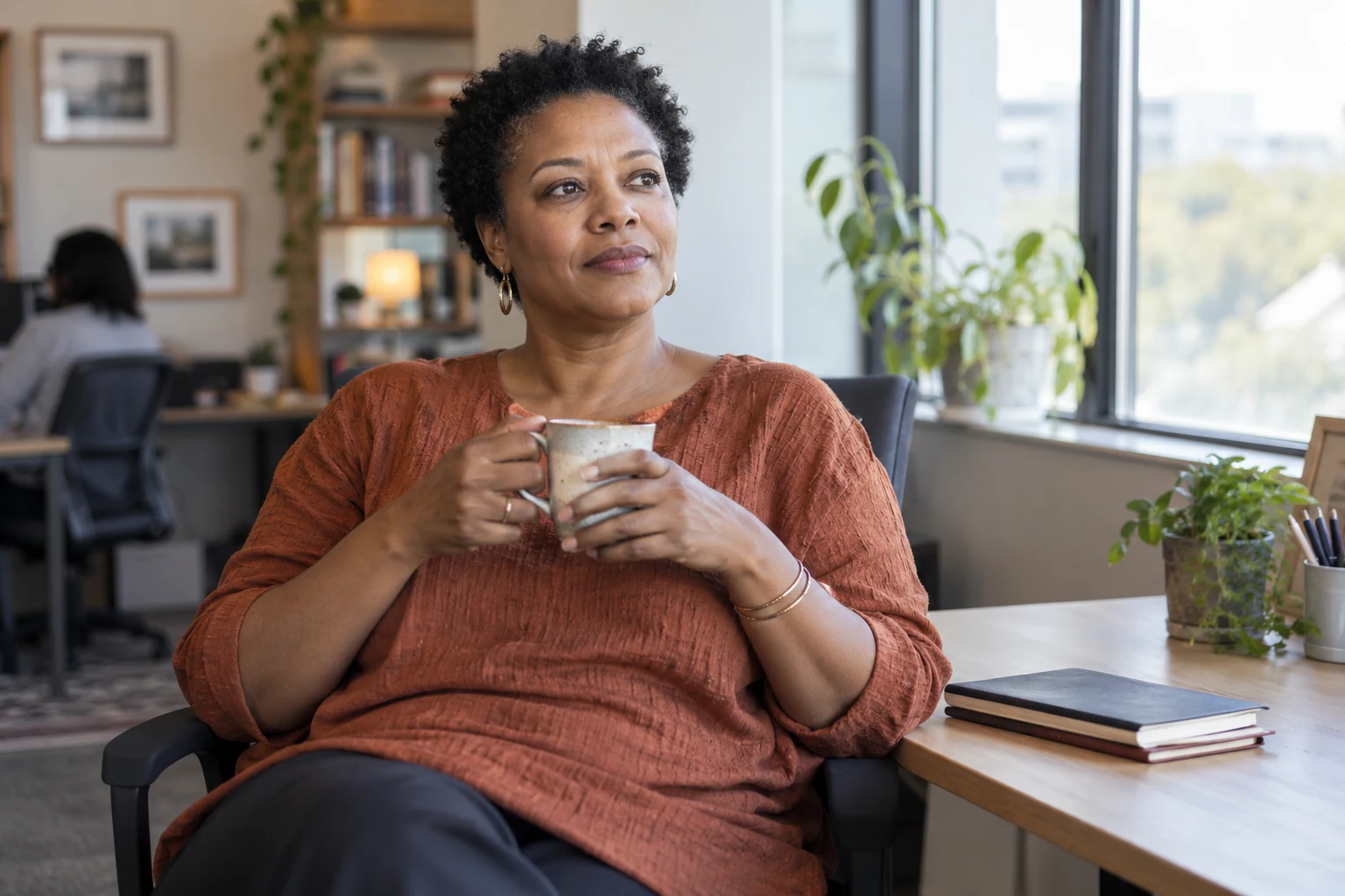 An adult takes a break near an office window.