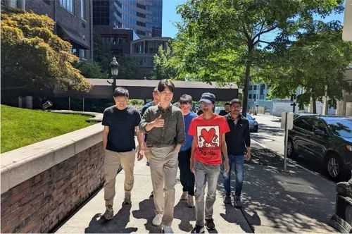 A group of Moloco interns walking down a city street, with buildings and trees in the background.