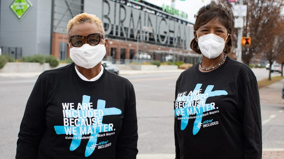 Acclinate - Two African American women with N95 masks wear shirts that read: "We are included because we matter" as part of the Alabama Conference of Black Mayors for a program called #NowIncluded which is a project to increase diversity in clinical trials by Acclinate. Acclinate is invested in by the Ruthless for Good Fund. 