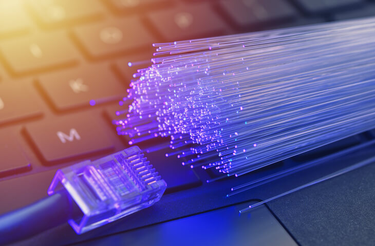 Fiber optics in blue, close up with ethernet and keyboard background